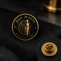 Gold hard enamel pin of the Bar Magic Innovations brain-and-shaker logo
